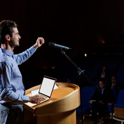 Male business executive giving a speech at conference center